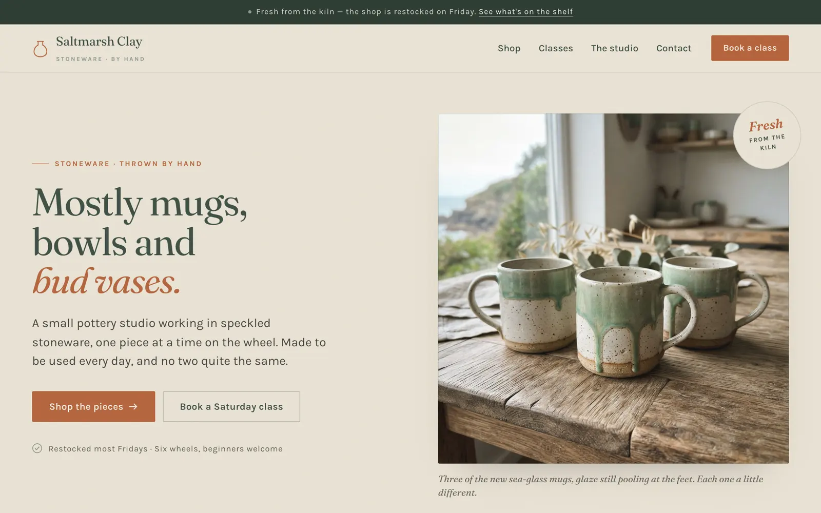 Desktop screenshot of the Saltmarsh Clay home page: ‘Mostly mugs, bowls and bud vases.’ beside a photo of three sea-glass mugs.